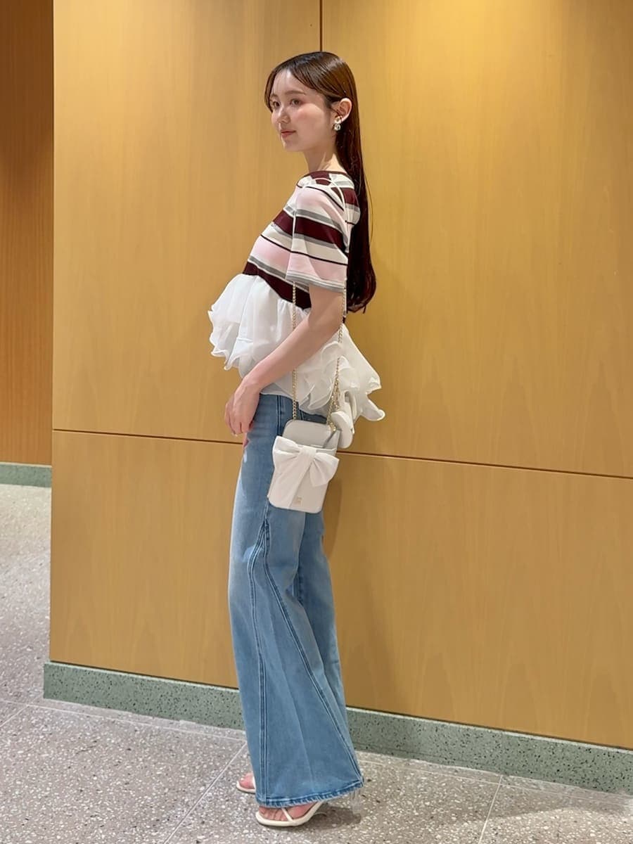 ブルー系のデニムパンツ、ピンク系のTシャツ/カットソー、ホワイト系のショルダーバッグを着用したレディースの春コーディネートの2枚目の写真