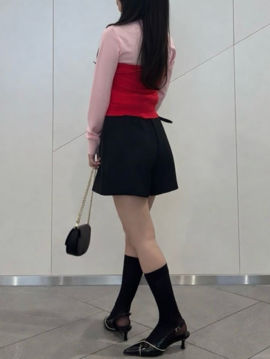 レッド系のカーディガン/ボレロ、ブラック系のパンプス、ブラック系のショルダーバッグを着用したレディースの冬コーディネートの4枚目の写真