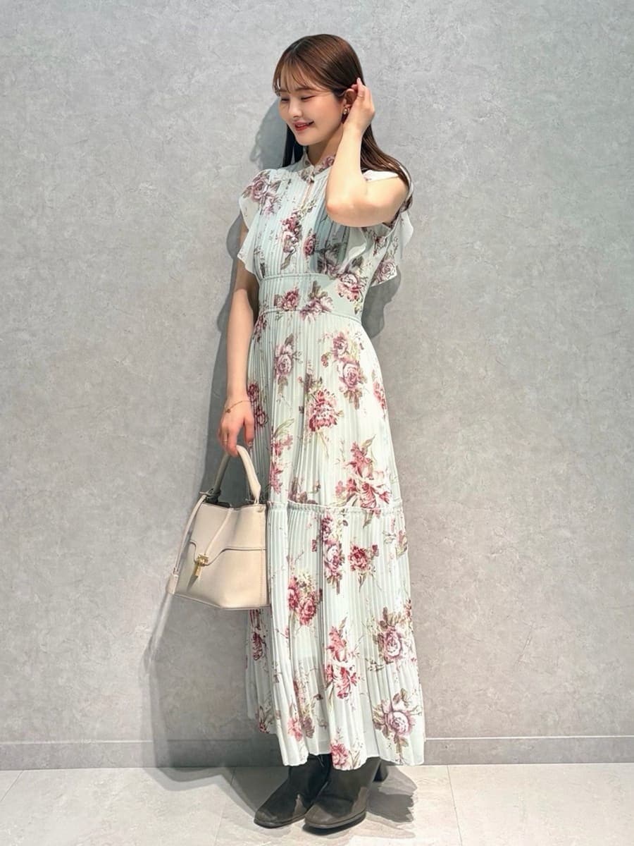 ホワイト系のテーラードジャケット、グリーン系のワンピース、ベージュ系のハンドバッグを着用したレディースの春コーディネートの5枚目の写真