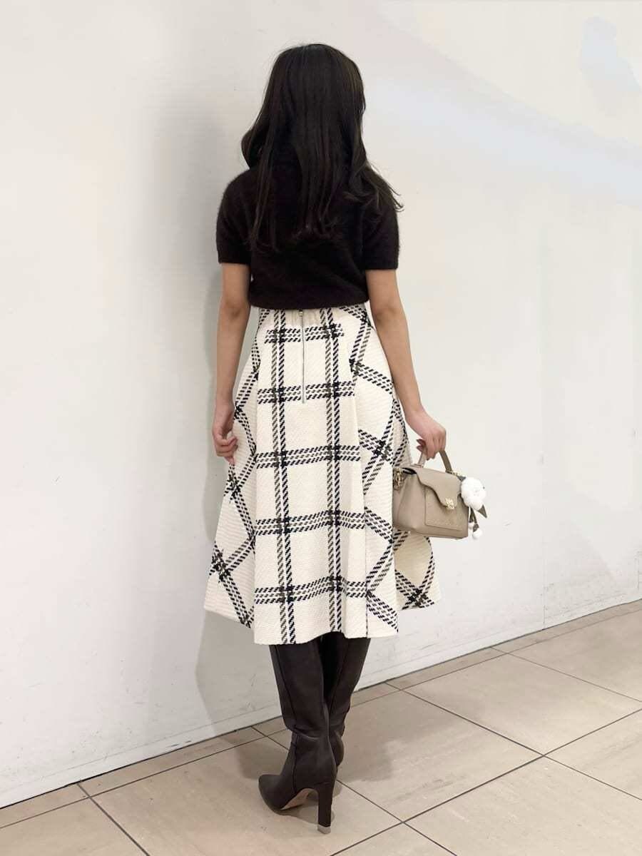 ブラウン系のニット/セーター、ホワイト系のスカート、ブラウン系のブーツを着用したレディースの秋コーディネートの5枚目の写真