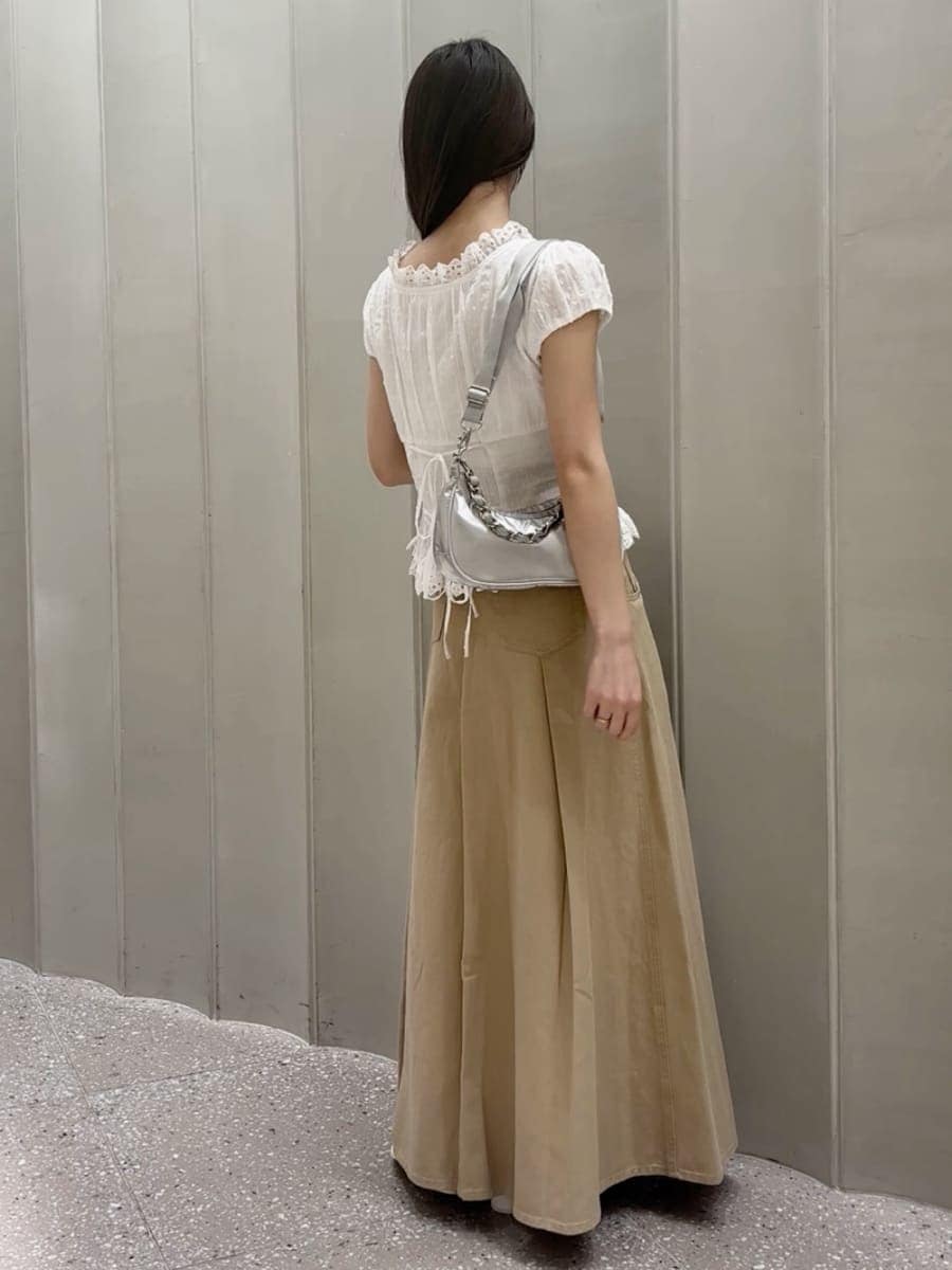 ベージュ系のスカート、ホワイト系のシャツ/ブラウス、シルバー系のショルダーバッグを着用したレディースの春コーディネートの4枚目の写真