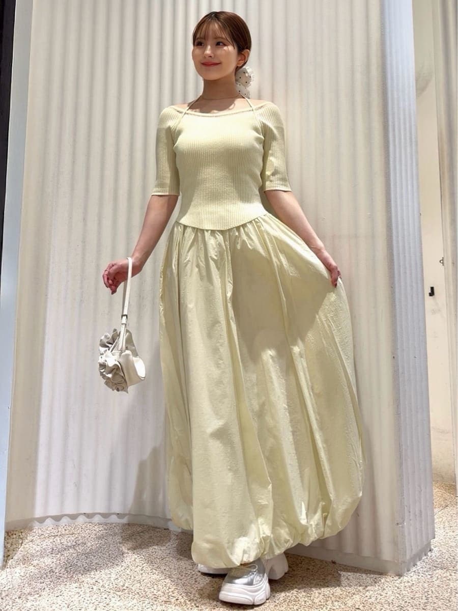 ホワイト系のハンドバッグ、ホワイト系のパンプス、ゴールド系のイヤリングを着用したレディースの春コーディネートの4枚目の写真