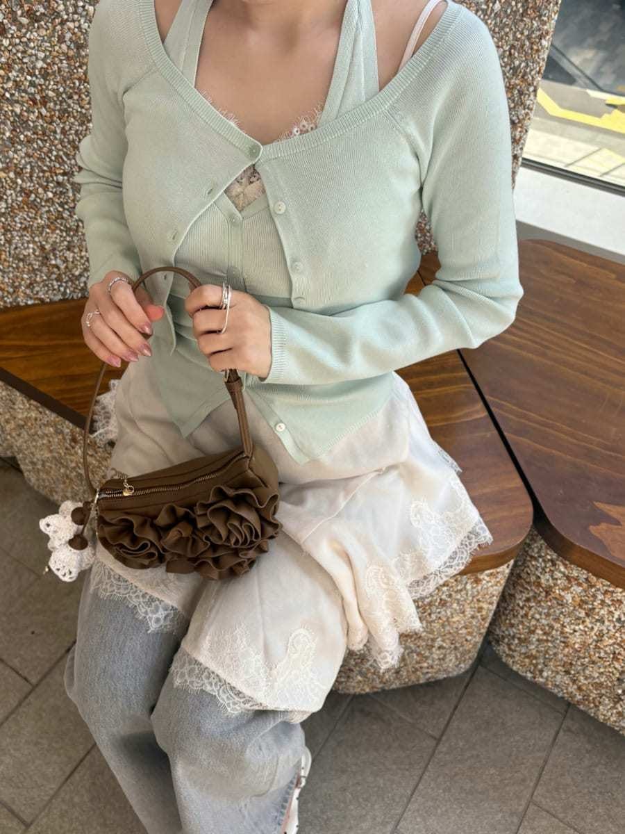 グレー系のデニムパンツ、ホワイト系のキャミソール、グリーン系のカーディガン/ボレロを着用したレディースの春コーディネートの7枚目の写真