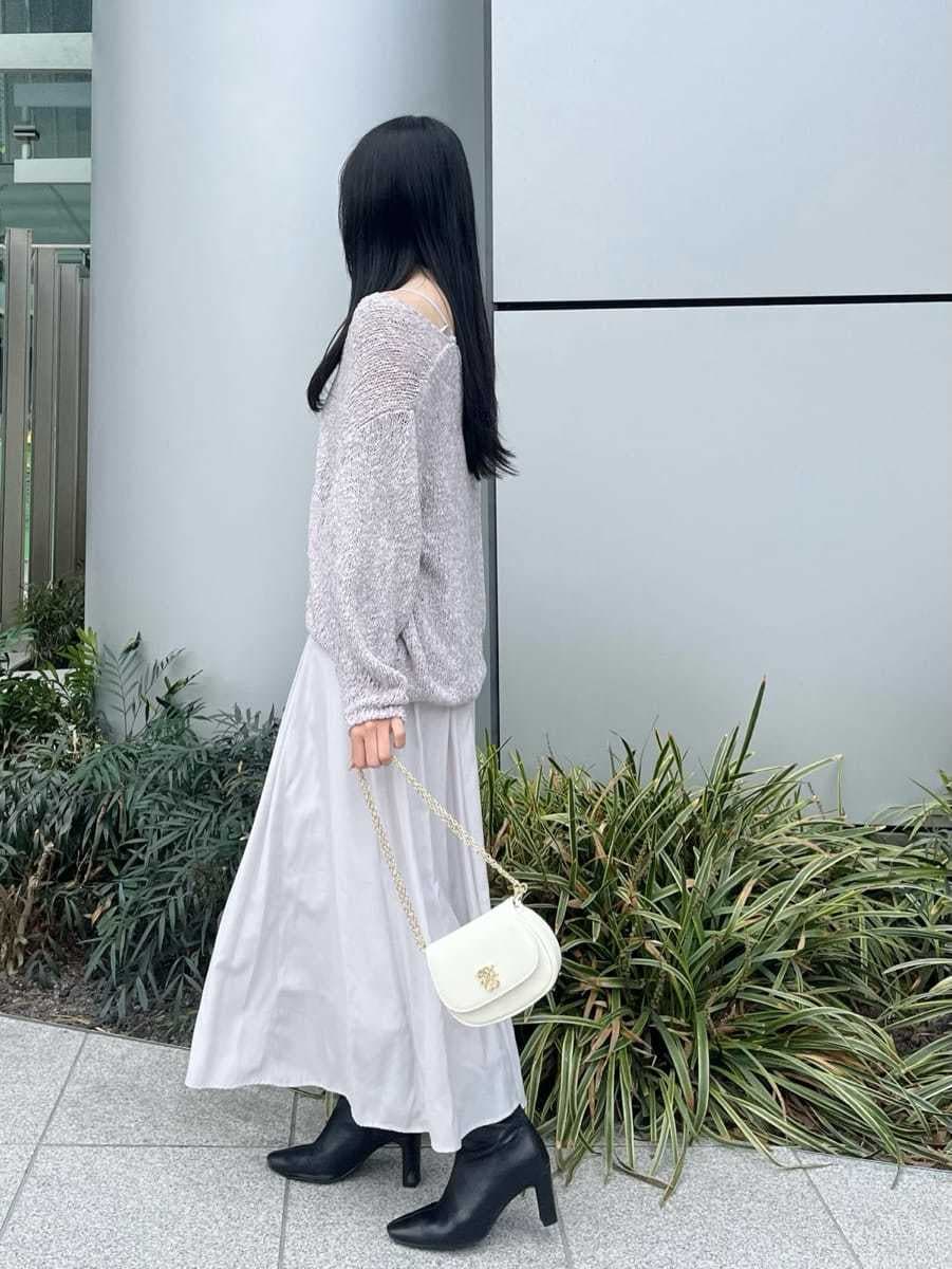 ブラック系のブーツ、パープル系のワンピース、ホワイト系のショルダーバッグを着用したレディースの冬コーディネートの2枚目の写真