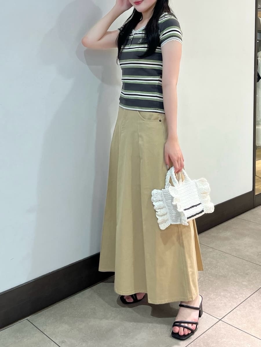 ベージュ系のスカート、グリーン系のTシャツ/カットソー、ホワイト系のショルダーバッグを着用したレディースの春コーディネートの2枚目の写真