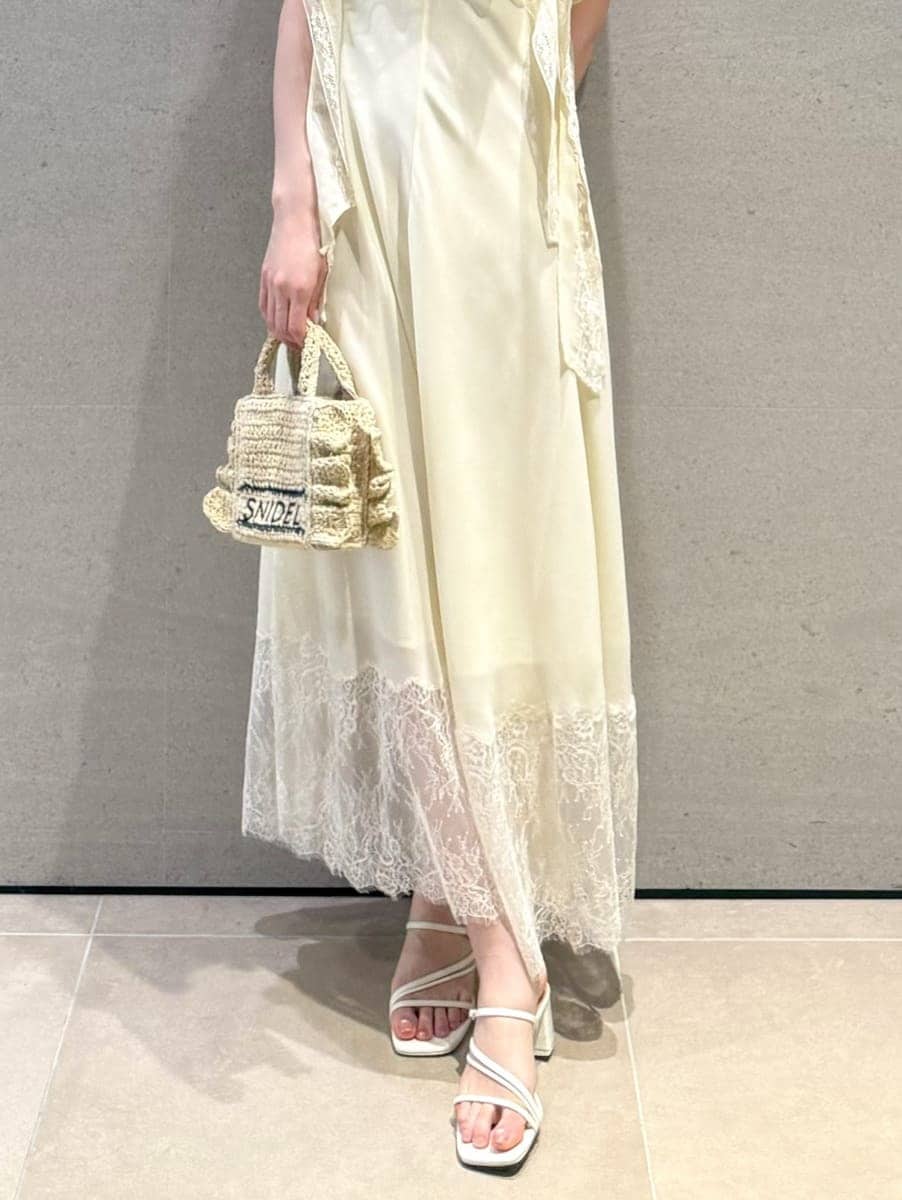 ベージュ系のショルダーバッグ、イエロー系のワンピース、ホワイト系のサンダルを着用したレディースの春コーディネートの5枚目の写真