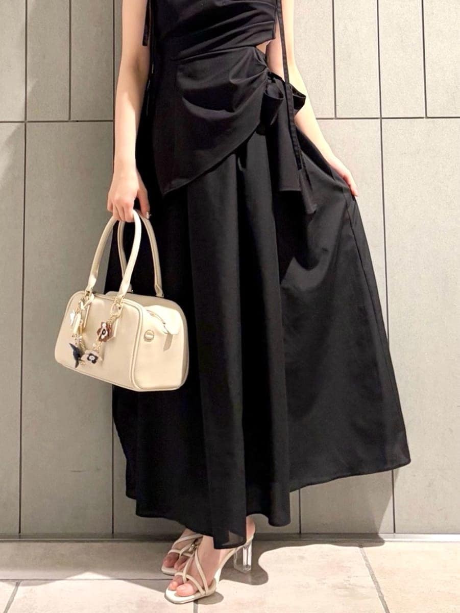 ブラック系のワンピース、グリーン系のTシャツ/カットソー、ホワイト系のボストンバッグを着用したレディースの春コーディネートの6枚目の写真