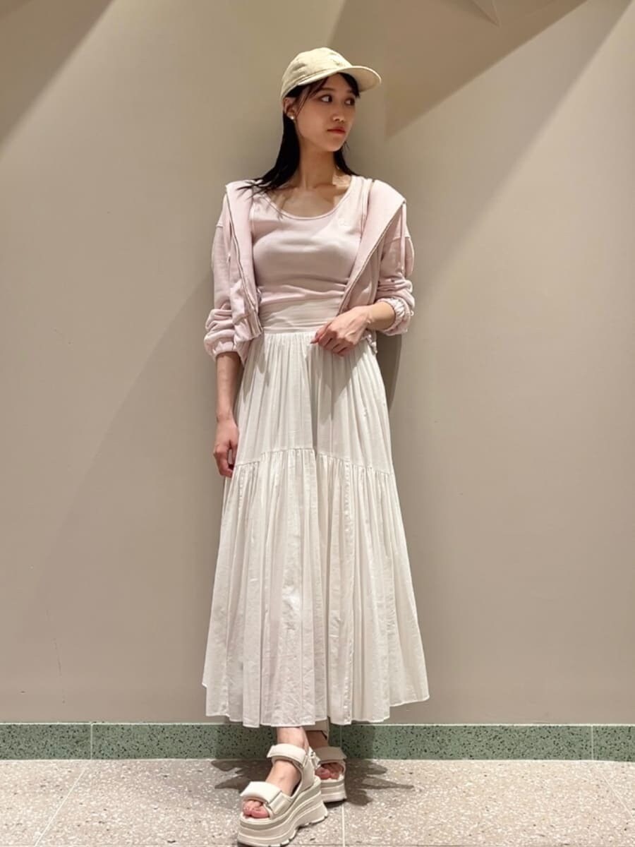 ピンク系のパーカー、ピンク系のタンクトップ、ホワイト系のスカートを着用したレディースの夏コーディネートの2枚目の写真