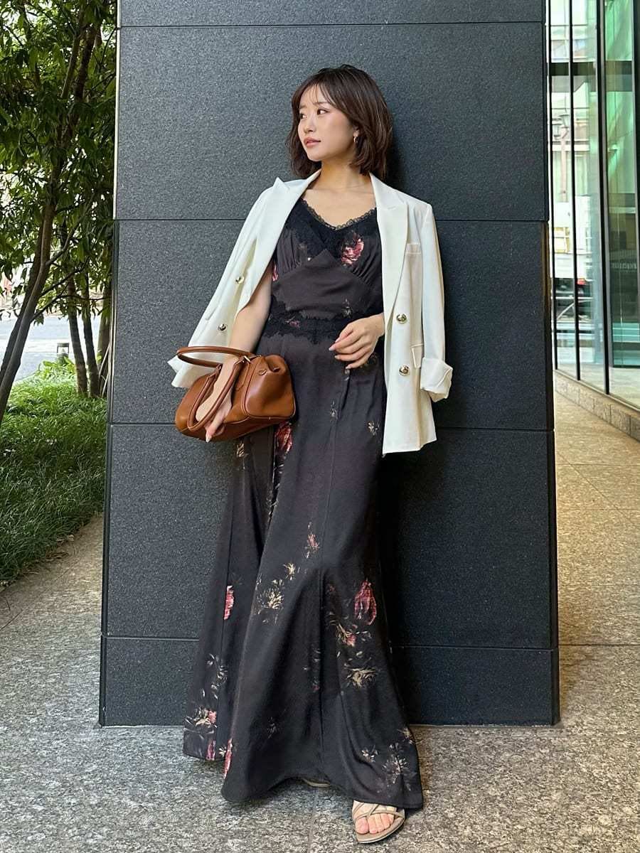 ブラック系のキャミソール、ホワイト系のテーラードジャケット、ブラック系のワンピースを着用したレディースの春コーディネートの2枚目の写真