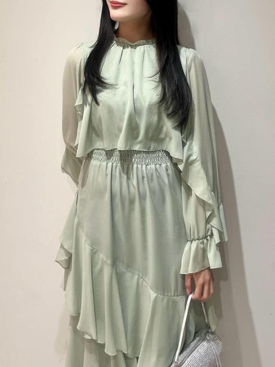 ブラック系のブーツ、ベージュ系のピーコート、グリーン系のワンピースを着用したレディースの冬コーディネートの7枚目の写真