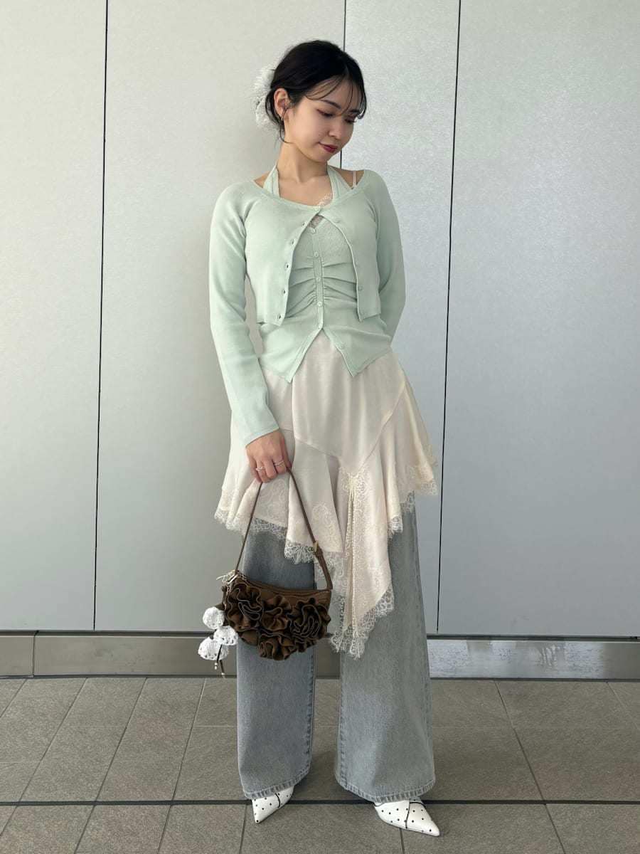 グレー系のデニムパンツ、ホワイト系のキャミソール、グリーン系のカーディガン/ボレロを着用したレディースの春コーディネートの2枚目の写真