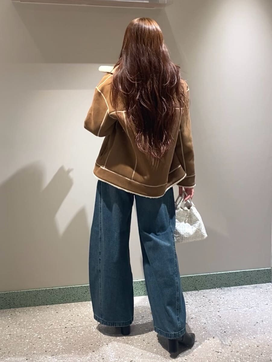 ブルー系のデニムパンツ、ブラウン系のニット/セーター、ブラック系のブーツを着用したレディースの秋コーディネートの5枚目の写真