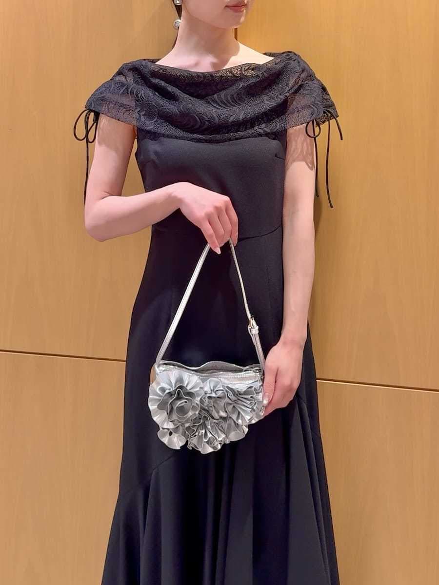 ブラック系のドレス、その他のパンプス、シルバー系のハンドバッグを着用したレディースの春コーディネートの7枚目の写真