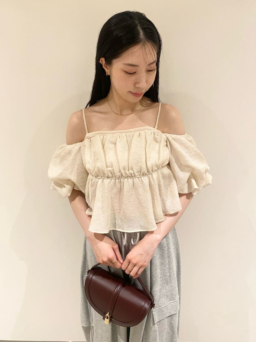 ホワイト系のシャツ/ブラウス、グレー系のその他パンツ、ブラウン系のハンドバッグを着用したレディースの秋コーディネートの2枚目の写真