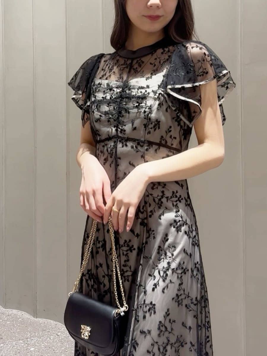 ブラック系のパンプス、ブラック系のショルダーバッグ、ブラック系のドレスを着用したレディースの春コーディネートの5枚目の写真