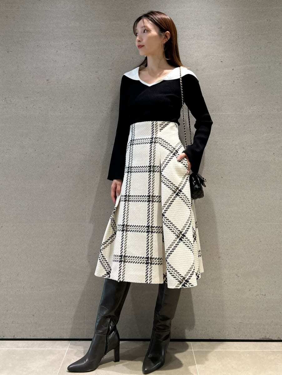 ブラック系のニット/セーター、ホワイト系のスカート、グレー系のブーツを着用したレディースの秋コーディネートの4枚目の写真