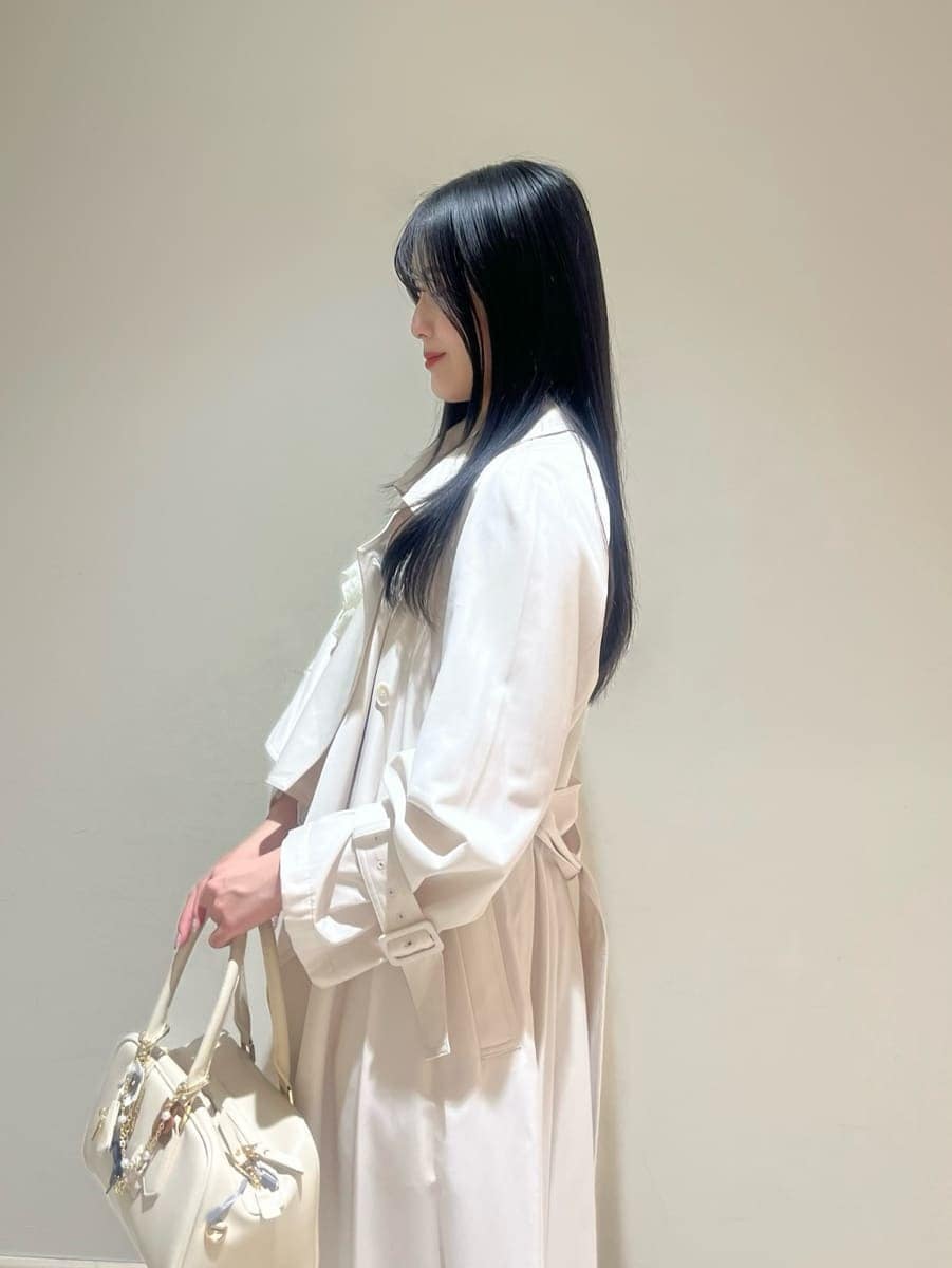 ブラック系のブーツ、ホワイト系のトレンチコート、グレー系のその他パンツを着用したレディースの冬コーディネートの4枚目の写真