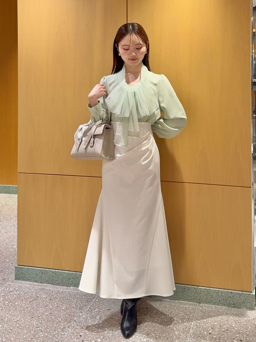 ブラック系のブーツ、ホワイト系のトレンチコート、ホワイト系のスカートを着用したレディースの冬コーディネートの4枚目の写真