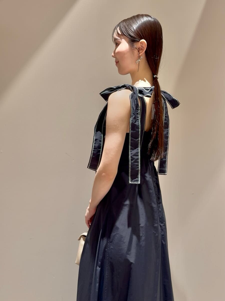 ブラック系のワンピース、ベージュ系のショルダーバッグ、シルバー系のネックレスを着用したレディースの夏コーディネートの5枚目の写真