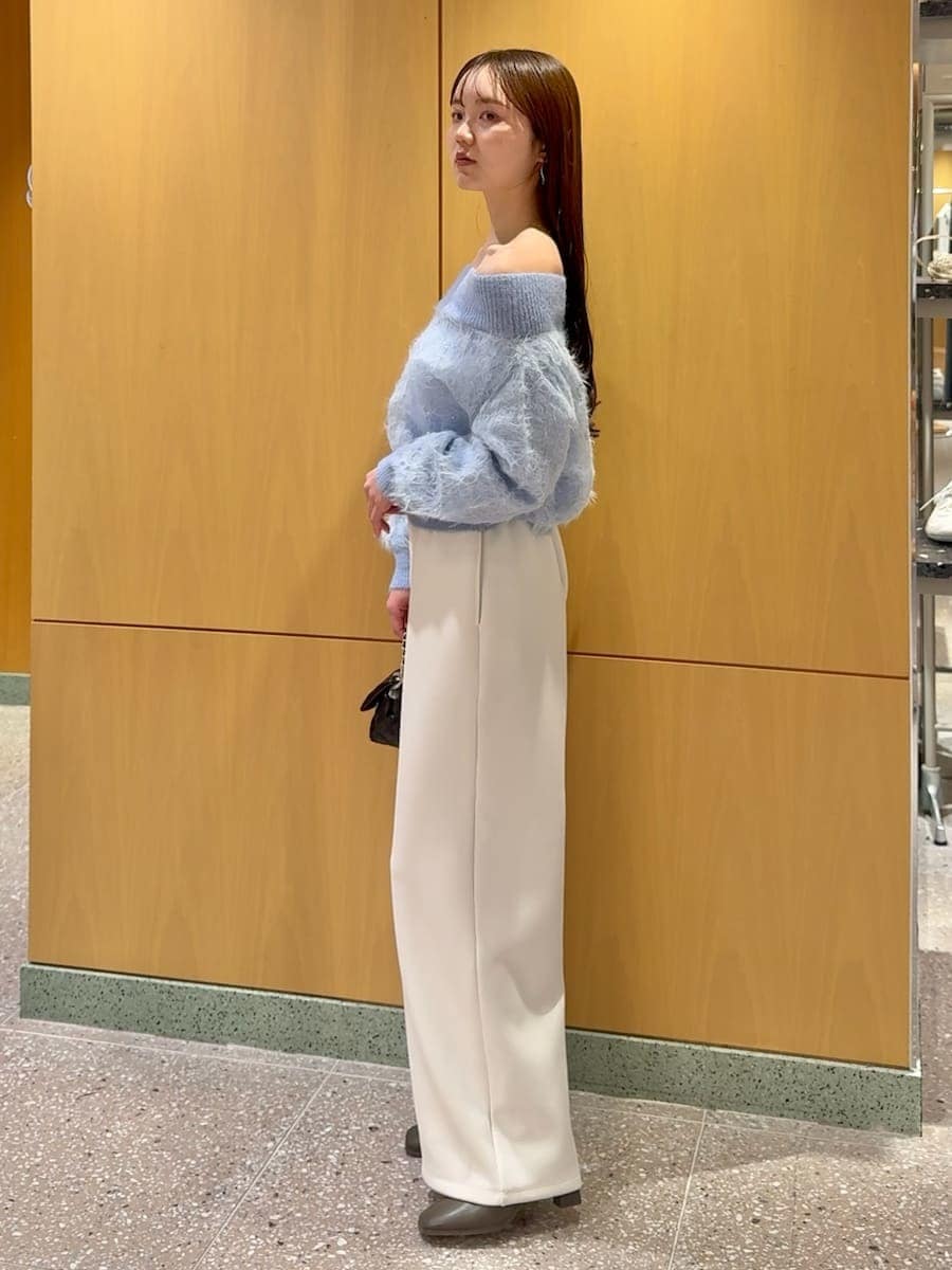 ブラック系のショルダーバッグ、ホワイト系のスウェットパンツ、ブルー系のニット/セーターを着用したレディースの冬コーディネートの2枚目の写真