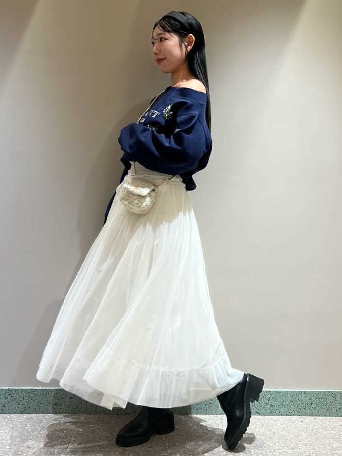 ブルー系のスウェット、ホワイト系のスカート、ホワイト系のショルダーバッグを着用したレディースの秋コーディネートの3枚目の写真