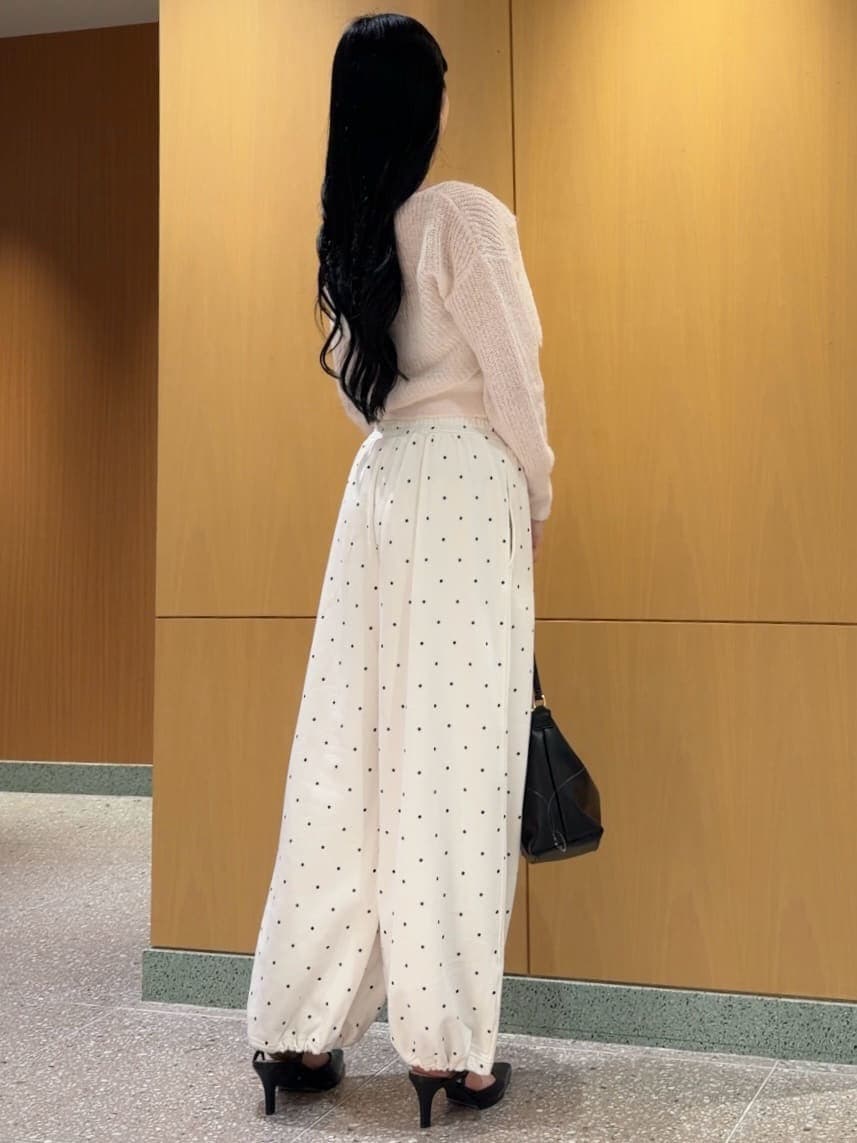 ピンク系のカーディガン/ボレロ、ブラック系のパンプス、ブラック系のショルダーバッグを着用したレディースの秋コーディネートの3枚目の写真