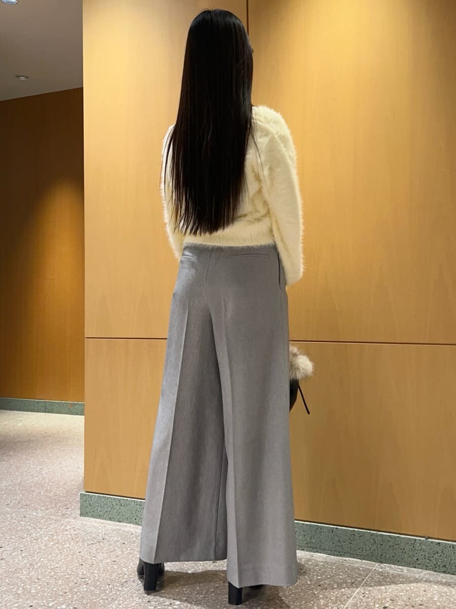 ブラック系のブーツ、イエロー系のニット/セーター、ブラック系のハンドバッグを着用したレディースの秋コーディネートの3枚目の写真