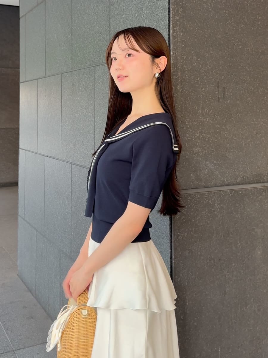 ホワイト系のかごバッグ、ホワイト系のスカート、ブルー系のニット/セーターを着用したレディースの夏コーディネートの5枚目の写真