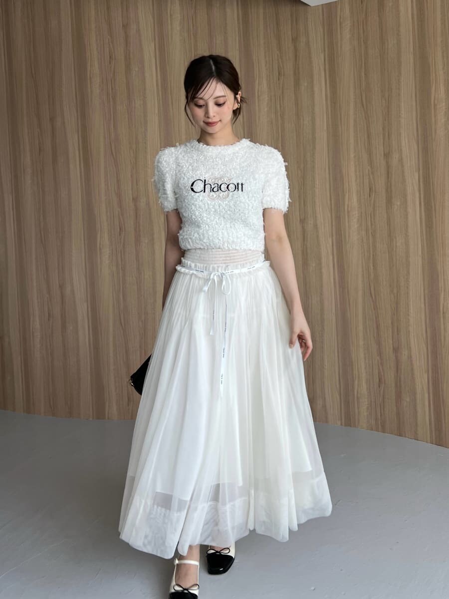 ホワイト系のニット/セーター、ホワイト系のスカート、ブラック系のハンドバッグを着用したレディースの夏コーディネートの4枚目の写真