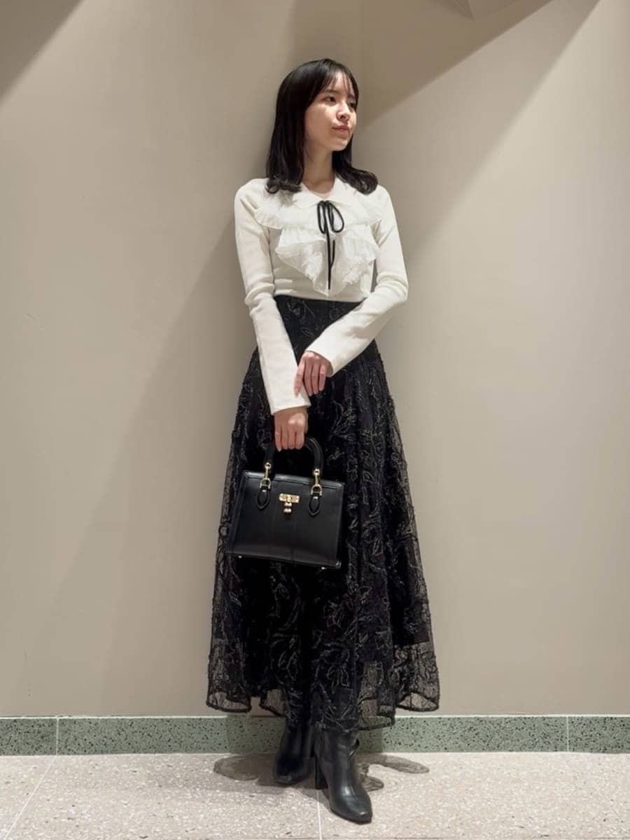 ブラック系のブーツ、グレー系のチェスターコート、ブラック系のスカートを着用したレディースの冬コーディネートの6枚目の写真