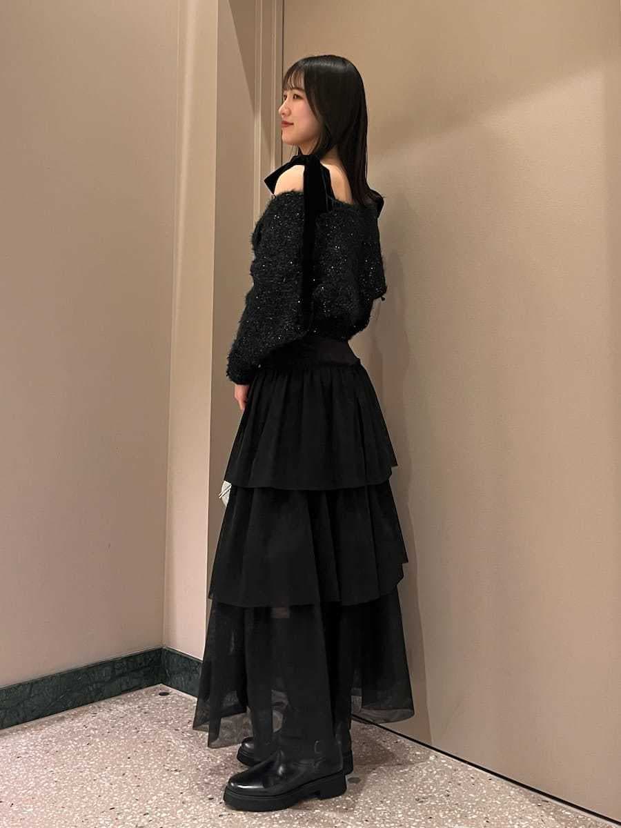 ブラック系のブーツ、ブラック系のスカート、ブラック系のニット/セーターを着用したレディースの冬コーディネートの2枚目の写真