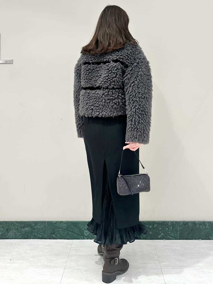 グレー系のムートンコート、ブラック系のスカートを着用したレディースの秋コーディネートの5枚目の写真