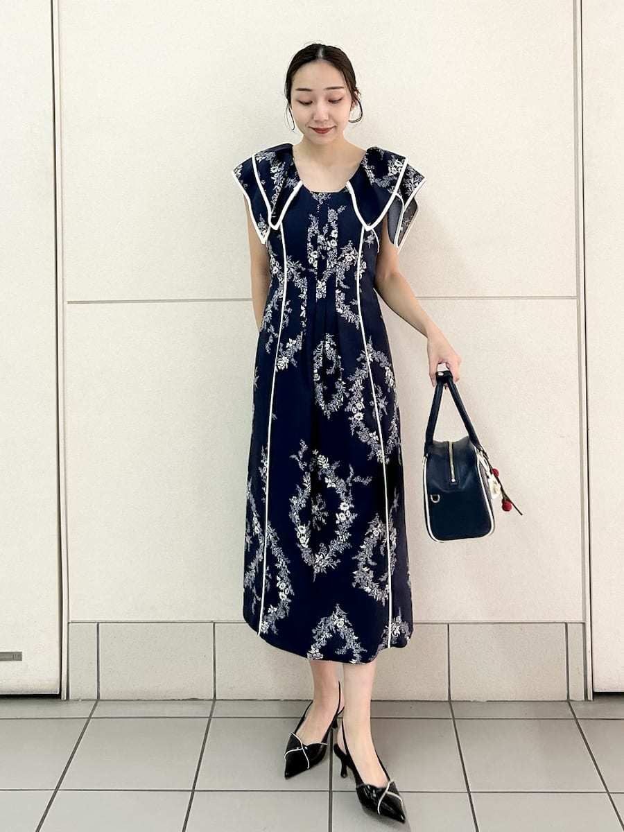 ブルー系のワンピース、ブラック系のパンプス、ブルー系のボストンバッグを着用したレディースの春コーディネートの3枚目の写真