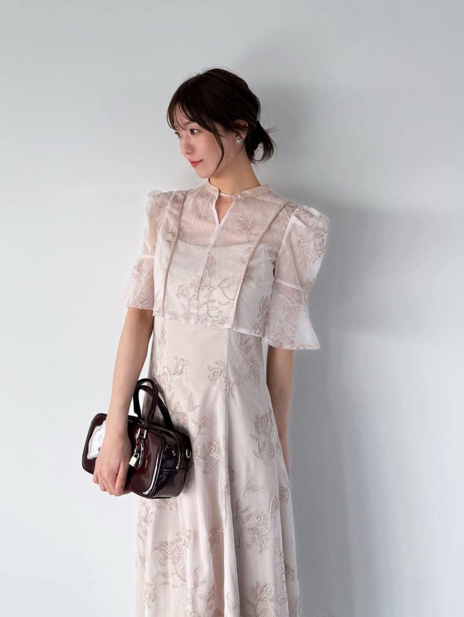 ピンク系のワンピース、ブラウン系のボストンバッグ、シルバー系のイヤリングを着用したレディースの夏コーディネートの3枚目の写真