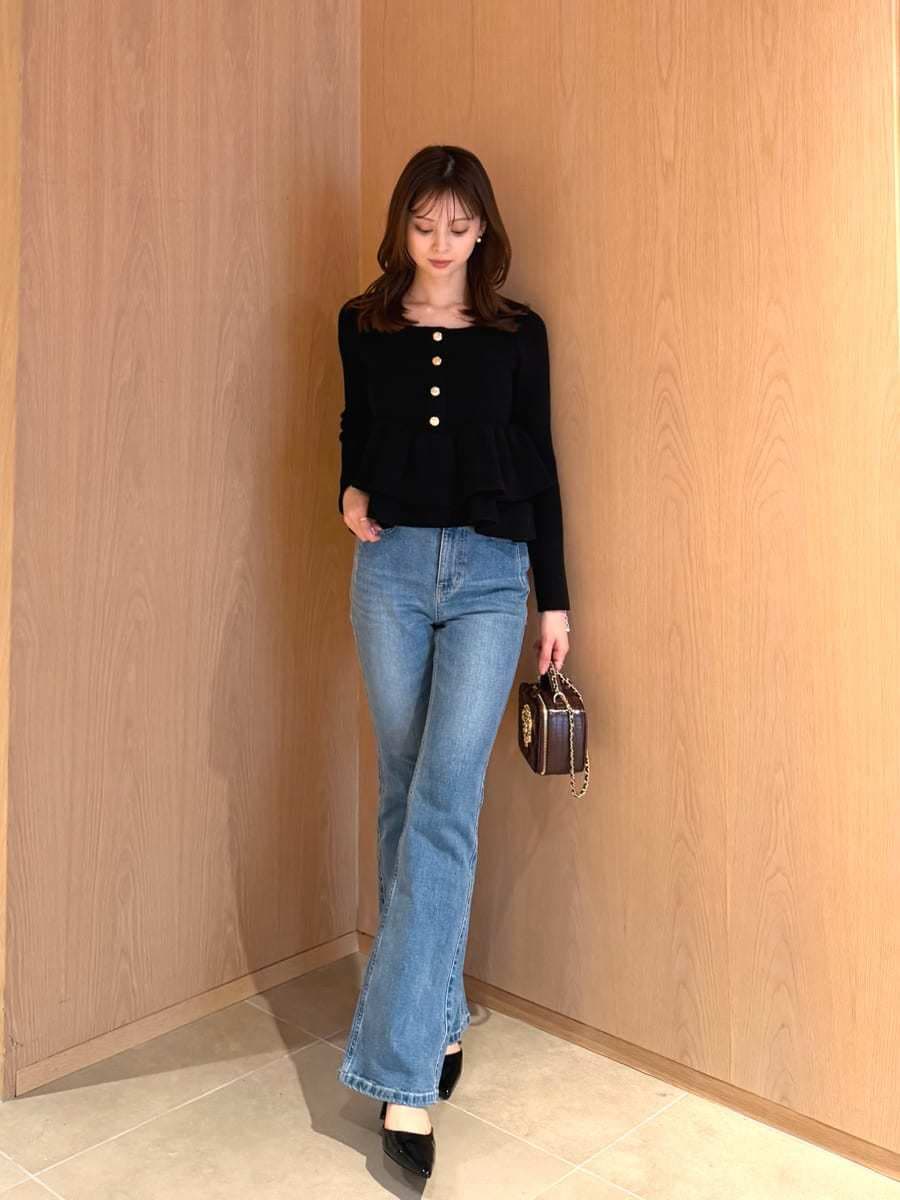 ブラック系のニット/セーター、レッド系のショルダーバッグ、ブルー系のデニムパンツを着用したレディースの秋コーディネートの2枚目の写真