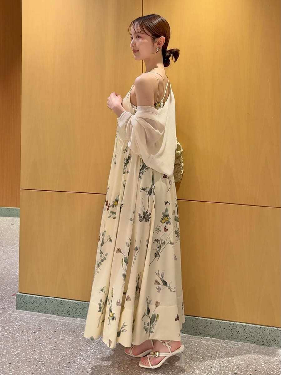 イエロー系のワンピース、ホワイト系のカーディガン/ボレロ、ベージュ系のショルダーバッグを着用したレディースの春コーディネートの2枚目の写真