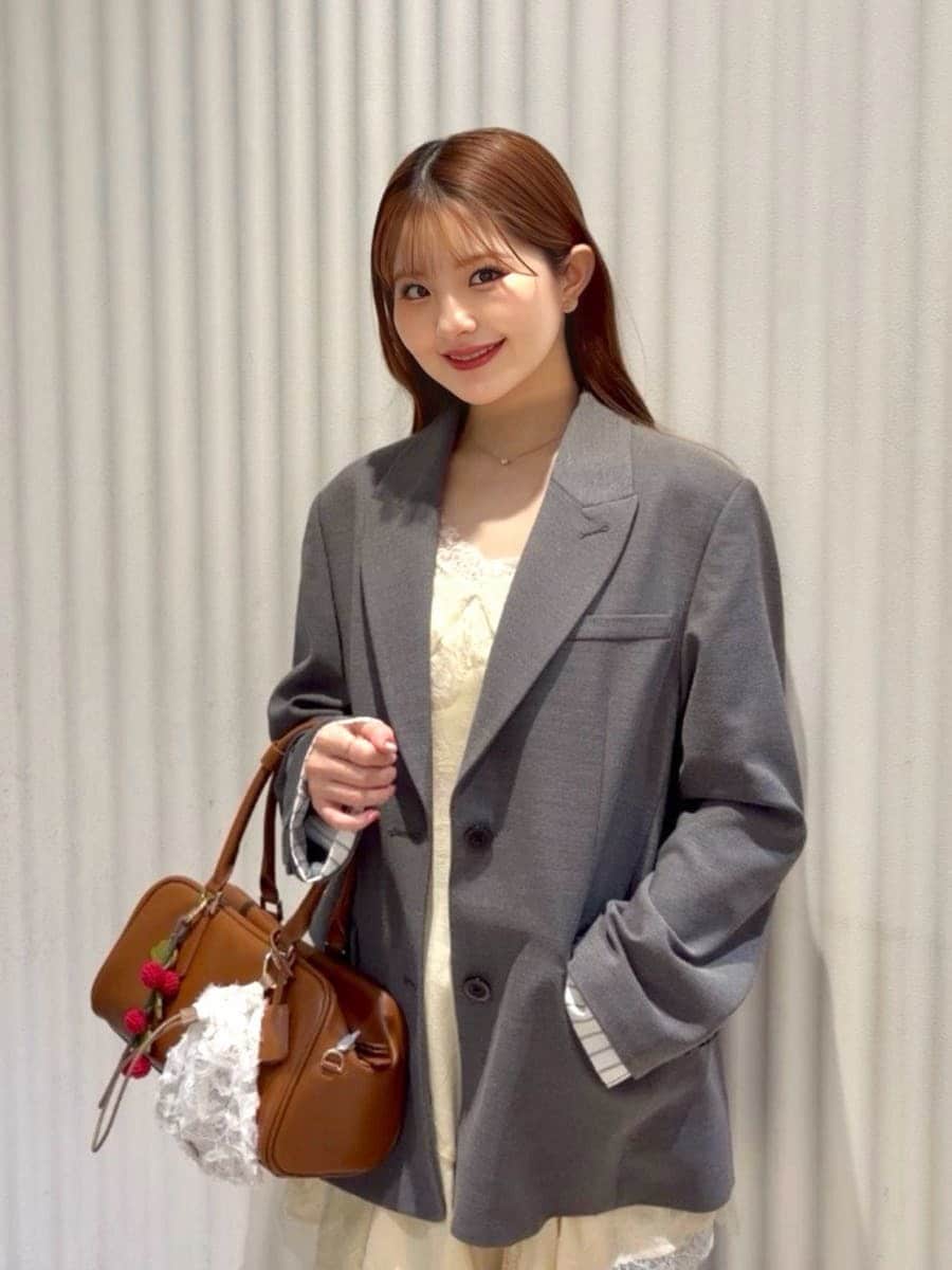 グレー系のテーラードジャケット、ブルー系のデニムパンツ、イエロー系のキャミソールを着用したレディースの春コーディネートの6枚目の写真