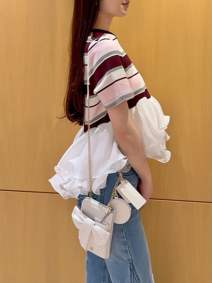 ブルー系のデニムパンツ、ピンク系のTシャツ/カットソー、ホワイト系のショルダーバッグを着用したレディースの春コーディネートの5枚目の写真