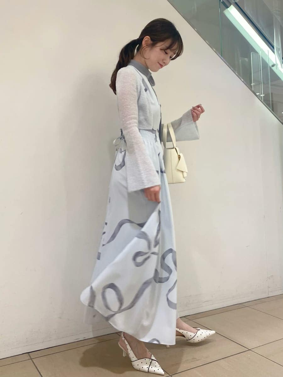 ブルー系のワンピース、その他のパンプス、ホワイト系のハンドバッグを着用したレディースの冬コーディネートの2枚目の写真