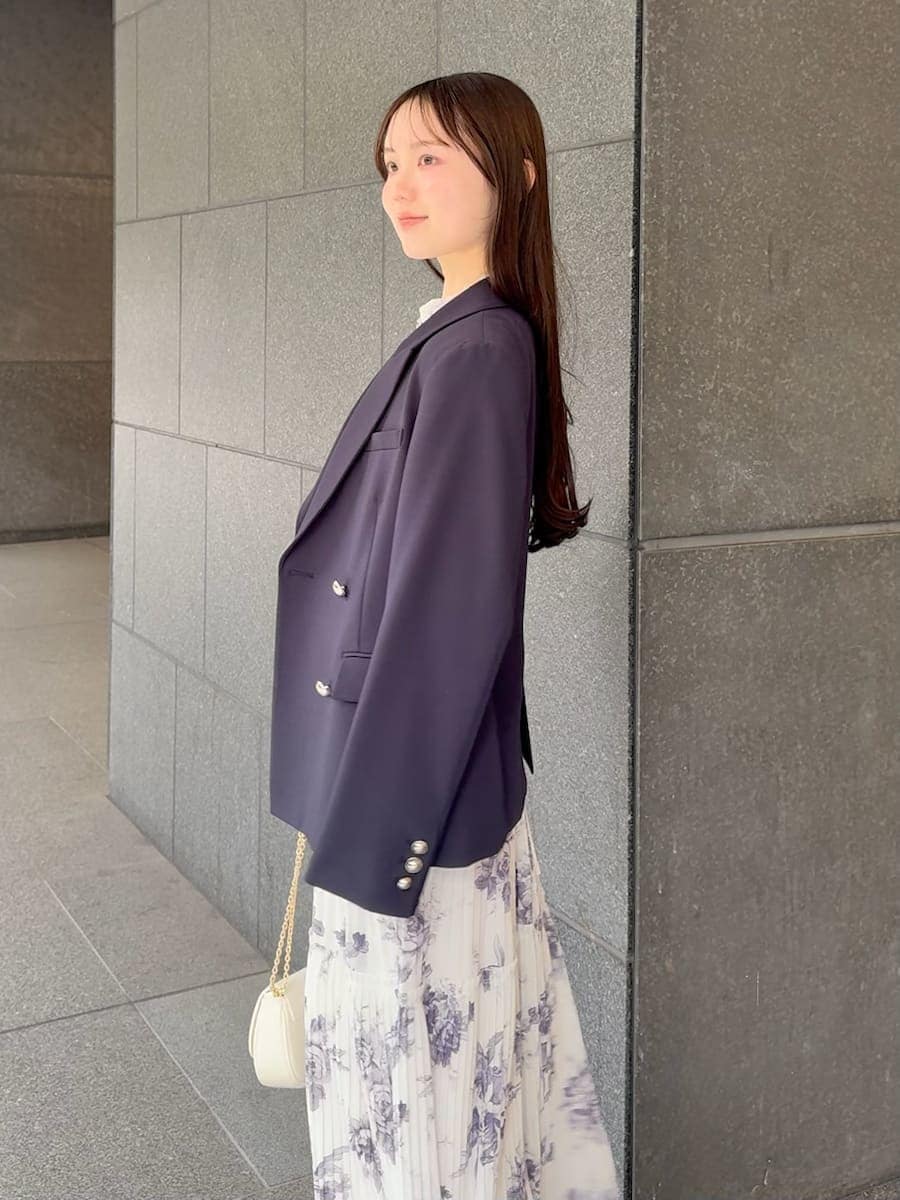 ブルー系のテーラードジャケット、ホワイト系のワンピース、ホワイト系のショルダーバッグを着用したレディースの春コーディネートの5枚目の写真