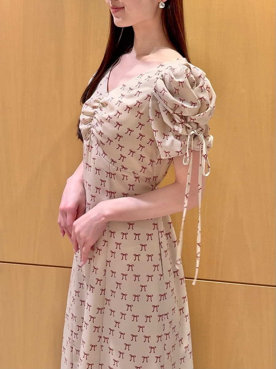 ホワイト系のハンドバッグ、ベージュ系のワンピース、レッド系のカーディガン/ボレロを着用したレディースの冬コーディネートの8枚目の写真