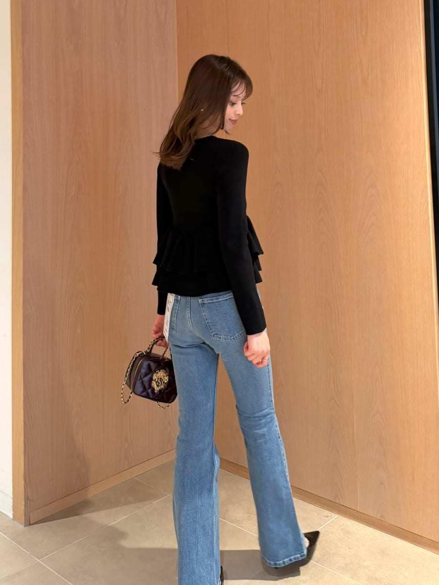 ブラック系のニット/セーター、レッド系のショルダーバッグ、ブルー系のデニムパンツを着用したレディースの秋コーディネートの3枚目の写真