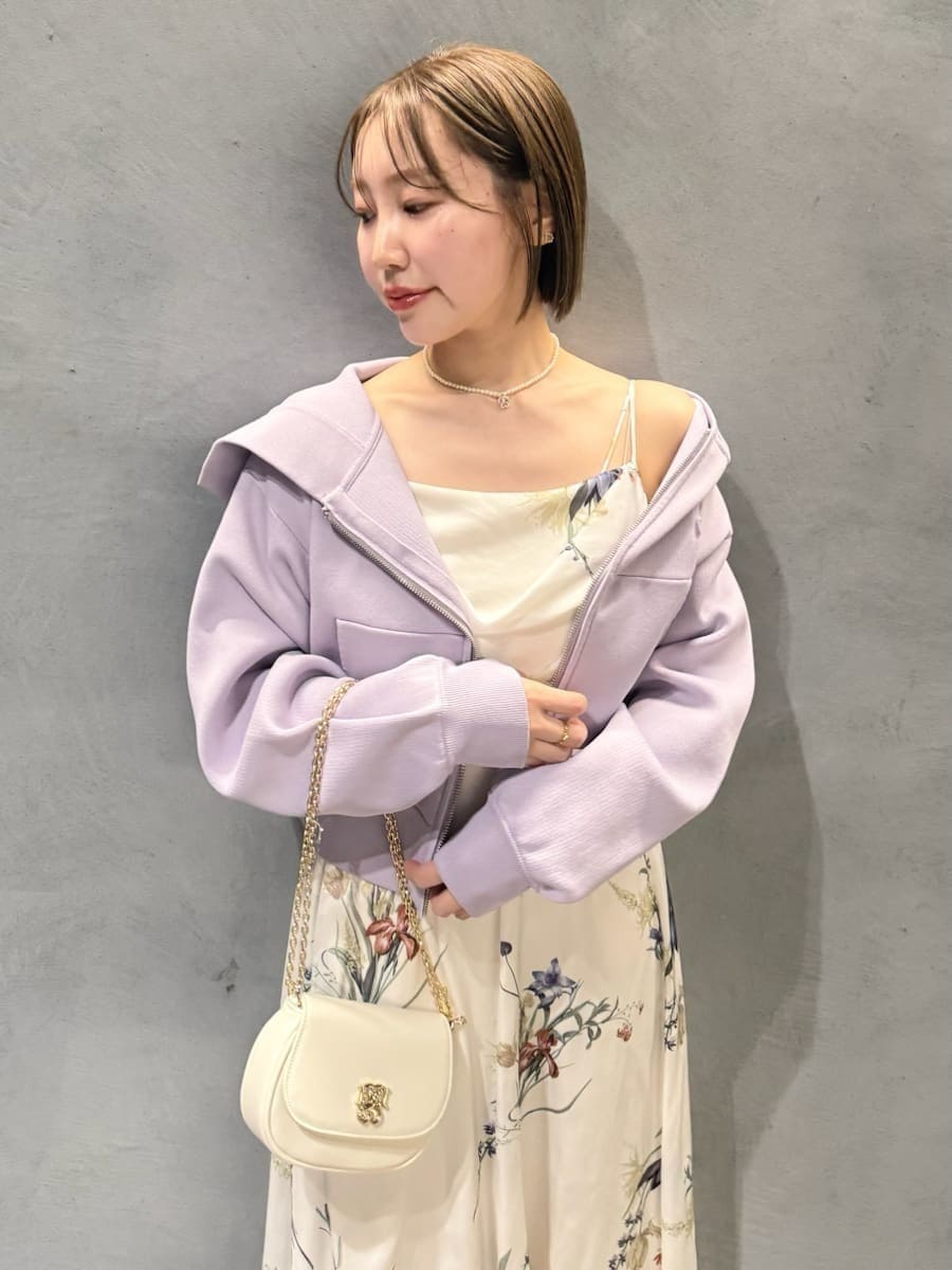 パープル系のパーカー、ホワイト系のワンピース、ブラウン系のパンプスを着用したレディースの冬コーディネートの4枚目の写真