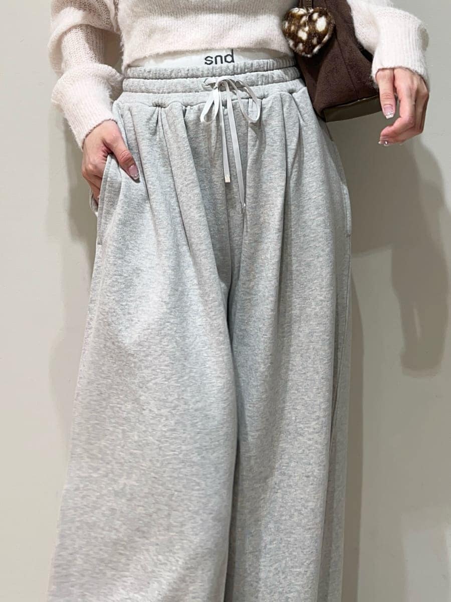グレー系のその他パンツ、ピンク系のカーディガン/ボレロ、ブラウン系のサンダルを着用したレディースの秋コーディネートの3枚目の写真