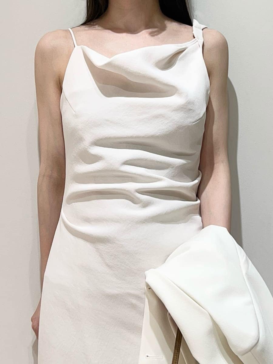 ホワイト系のテーラードジャケット、ホワイト系のワンピース、ブラウン系のパンプスを着用したレディースの春コーディネートの2枚目の写真