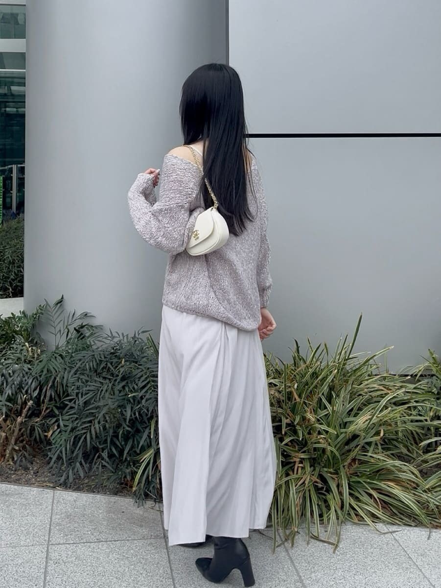 ブラック系のブーツ、パープル系のワンピース、ホワイト系のショルダーバッグを着用したレディースの冬コーディネートの3枚目の写真