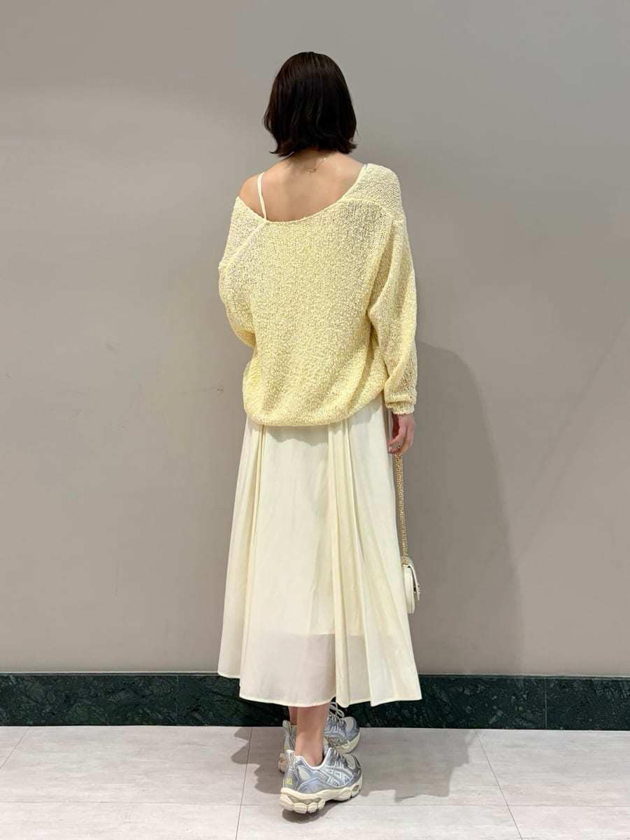 イエロー系のワンピース、ホワイト系のショルダーバッグ、シルバー系のスニーカーを着用したレディースの春コーディネートの3枚目の写真