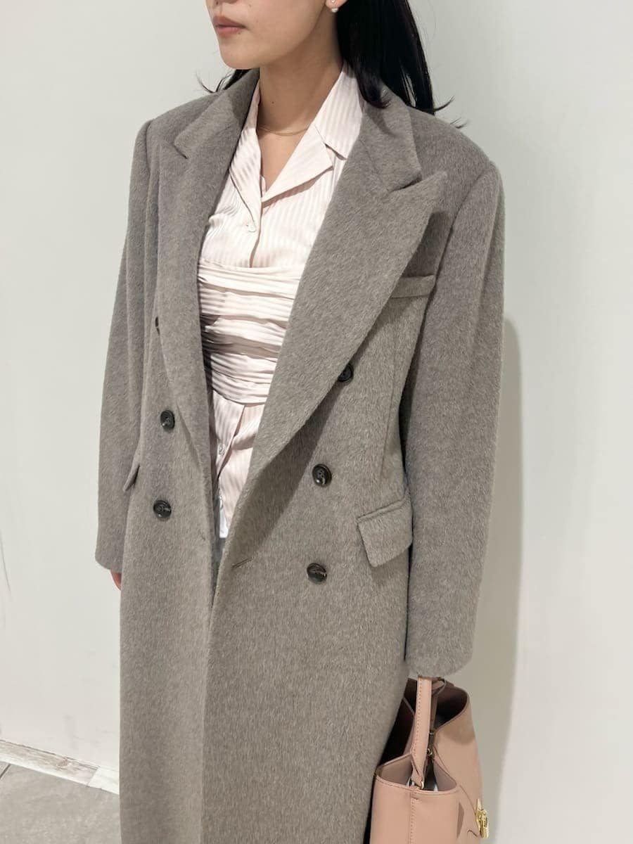 ピンク系のショルダーバッグ、ベージュ系のチェスターコート、ホワイト系のその他パンツを着用したレディースの冬コーディネートの4枚目の写真