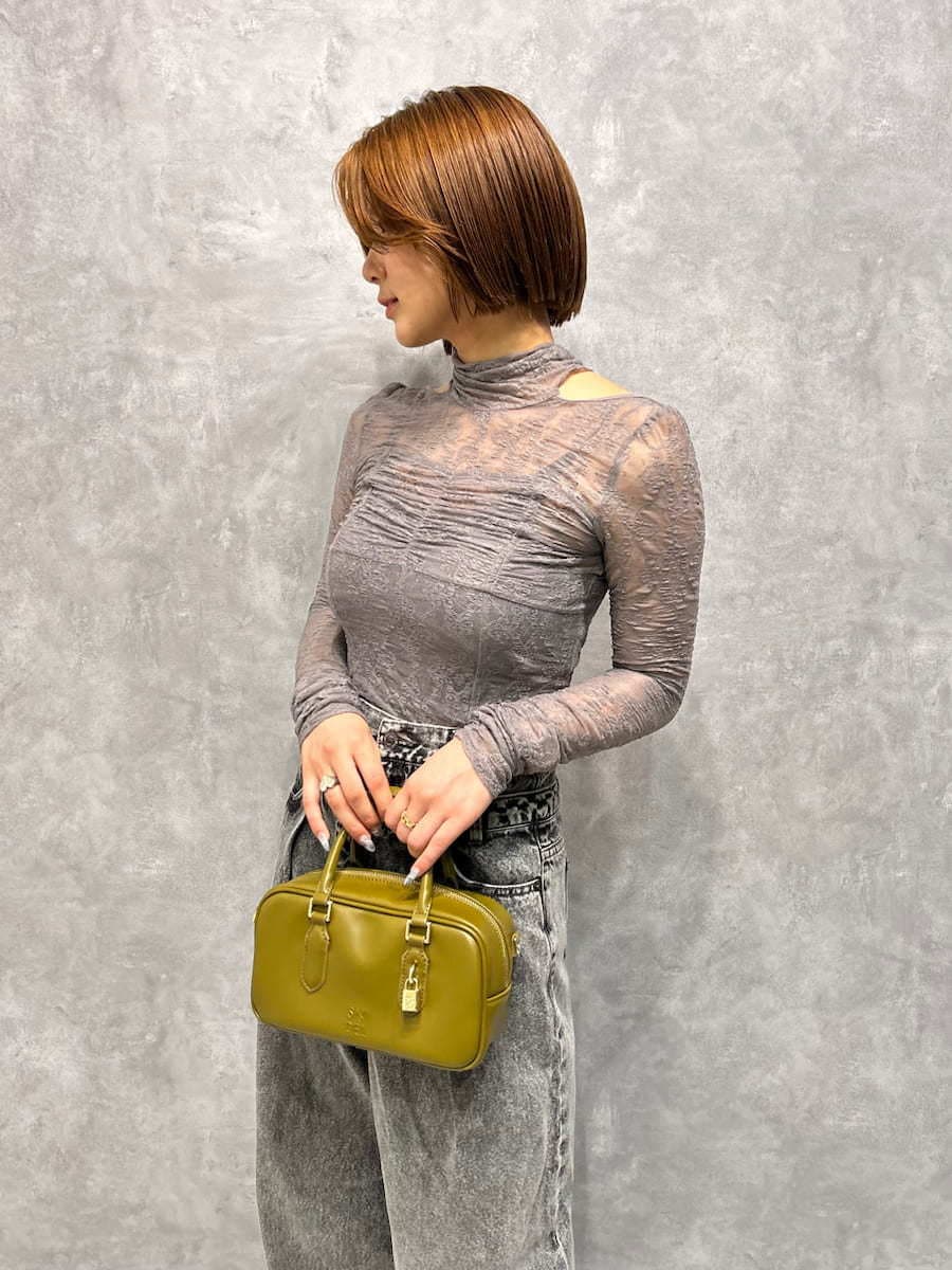 グレー系のTシャツ/カットソー、グレー系のデニムパンツ、グリーン系のボストンバッグを着用したレディースの秋コーディネートの5枚目の写真