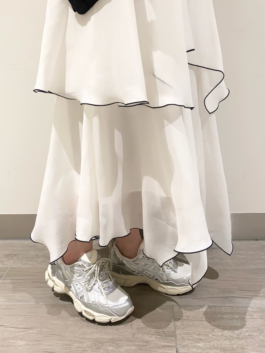 ホワイト系のワンピース、ブラック系のショルダーバッグ、シルバー系のスニーカーを着用したレディースの冬コーディネートの6枚目の写真